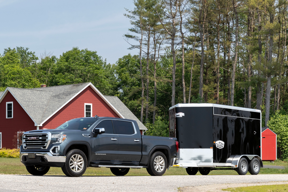 Black Truck Pulling Black Colt Big Sky Combo Slant Load Series In Road