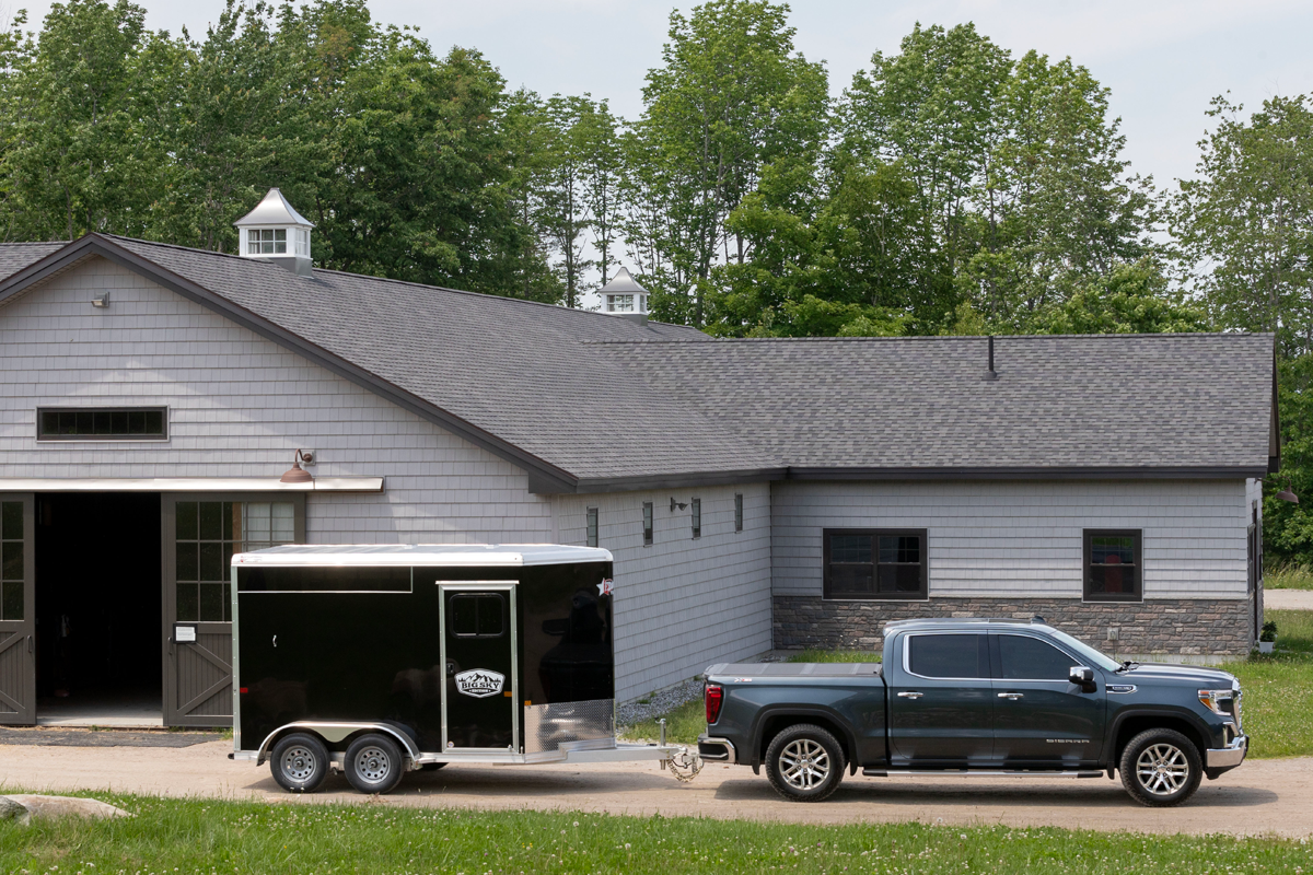 Black Truck Pulling Black Colt Big Sky Combo Slant Load Series Parked In Front Of Barn